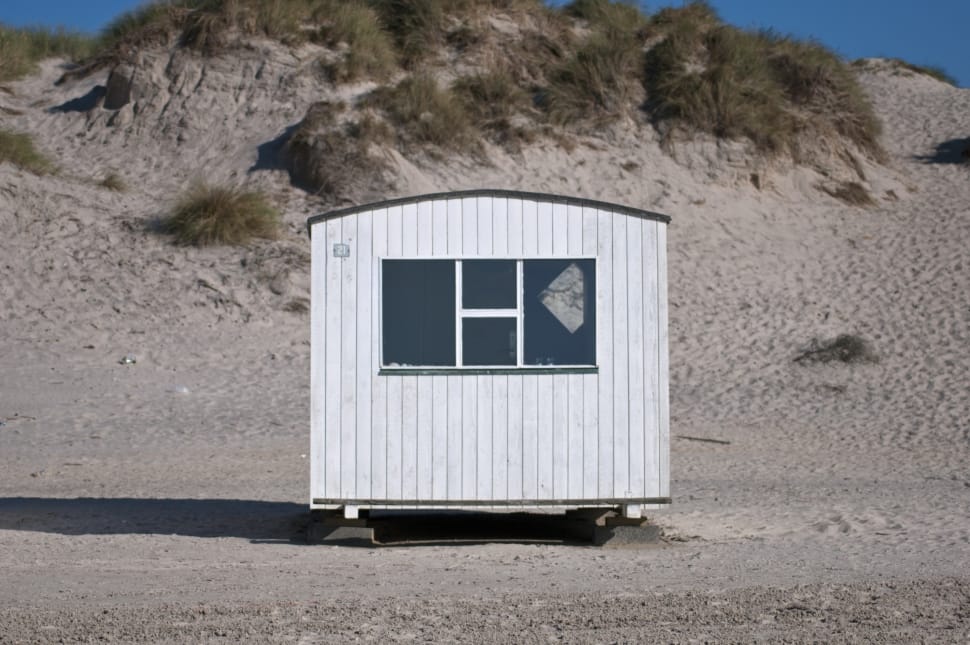white wooden shed on a gray sandy plateau preview