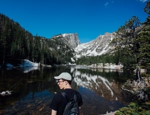 man wearing black t-shirt looking at lake during day time thumbnail