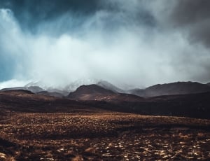 brown mountains under white clouds during daytime thumbnail