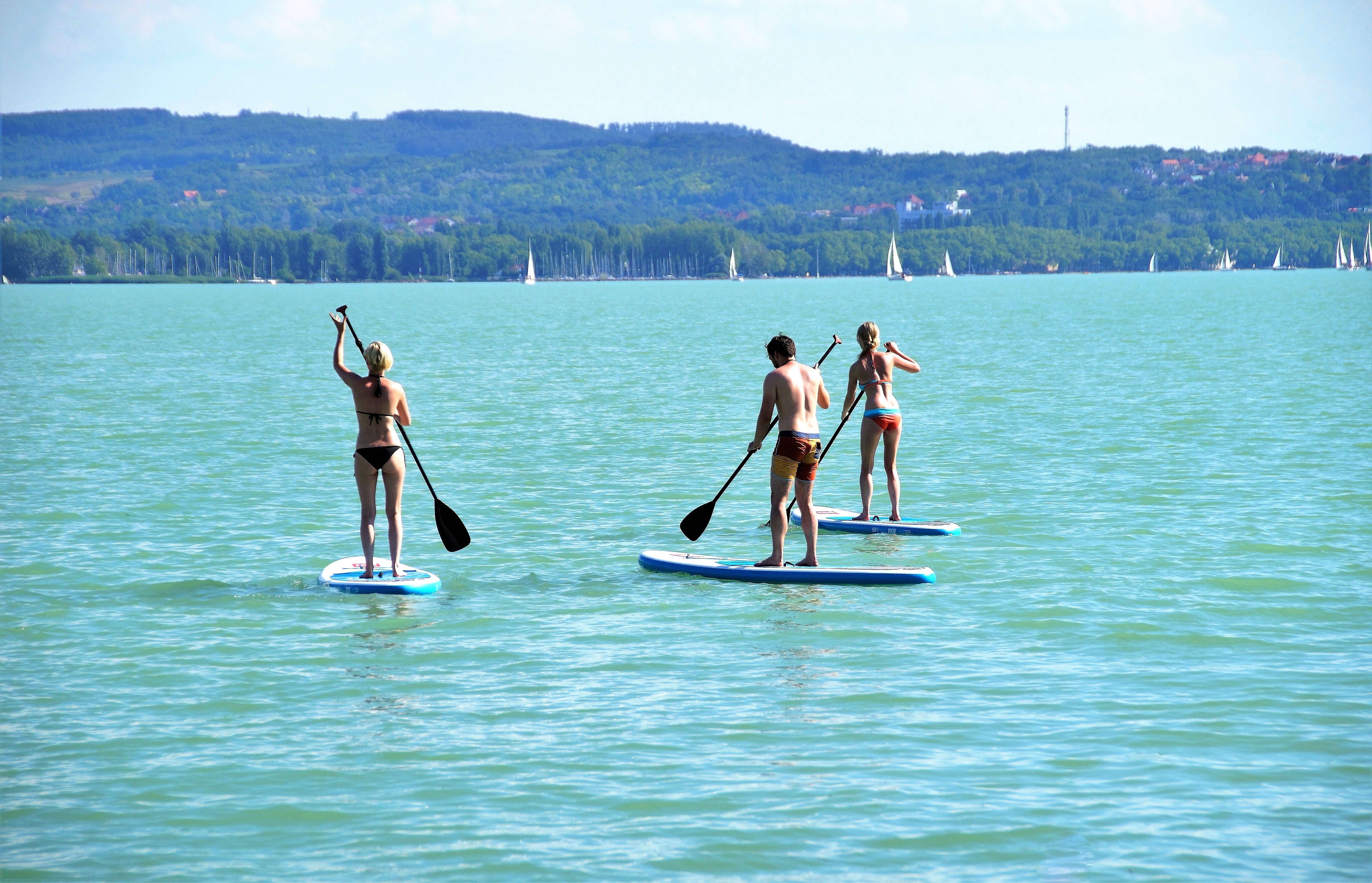 3 people standing on surf board