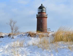 brown lighthouse surrounded by snow thumbnail