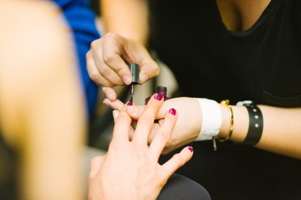 woman putting nail polish to woman preview