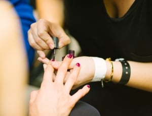 woman putting nail polish to woman thumbnail