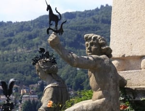 brown statues holding unicorn wind vane thumbnail