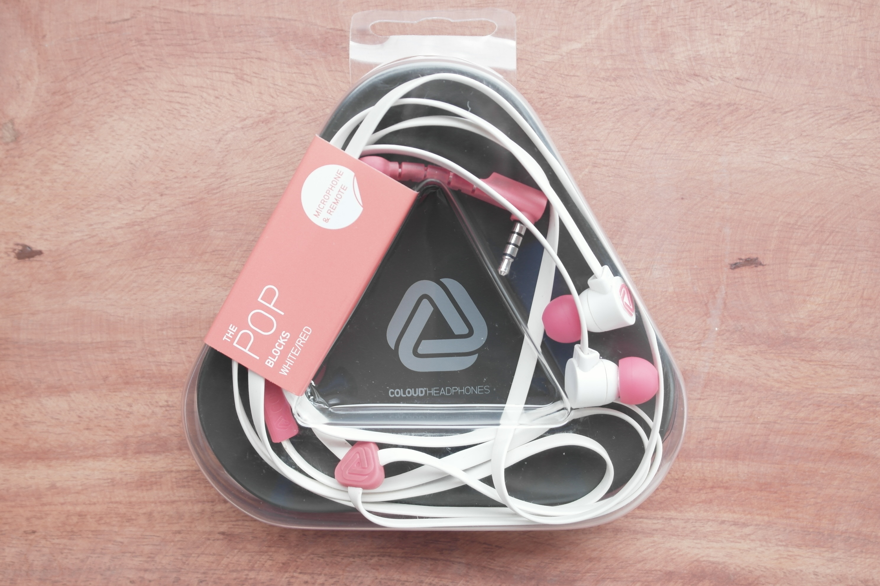 pink and white pop earphones in plastic pack