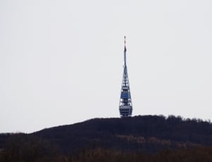 blue and grey tower building in middle of forest thumbnail