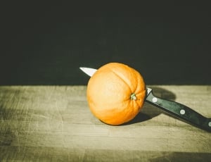 black handled knife in orange citrus fruit thumbnail