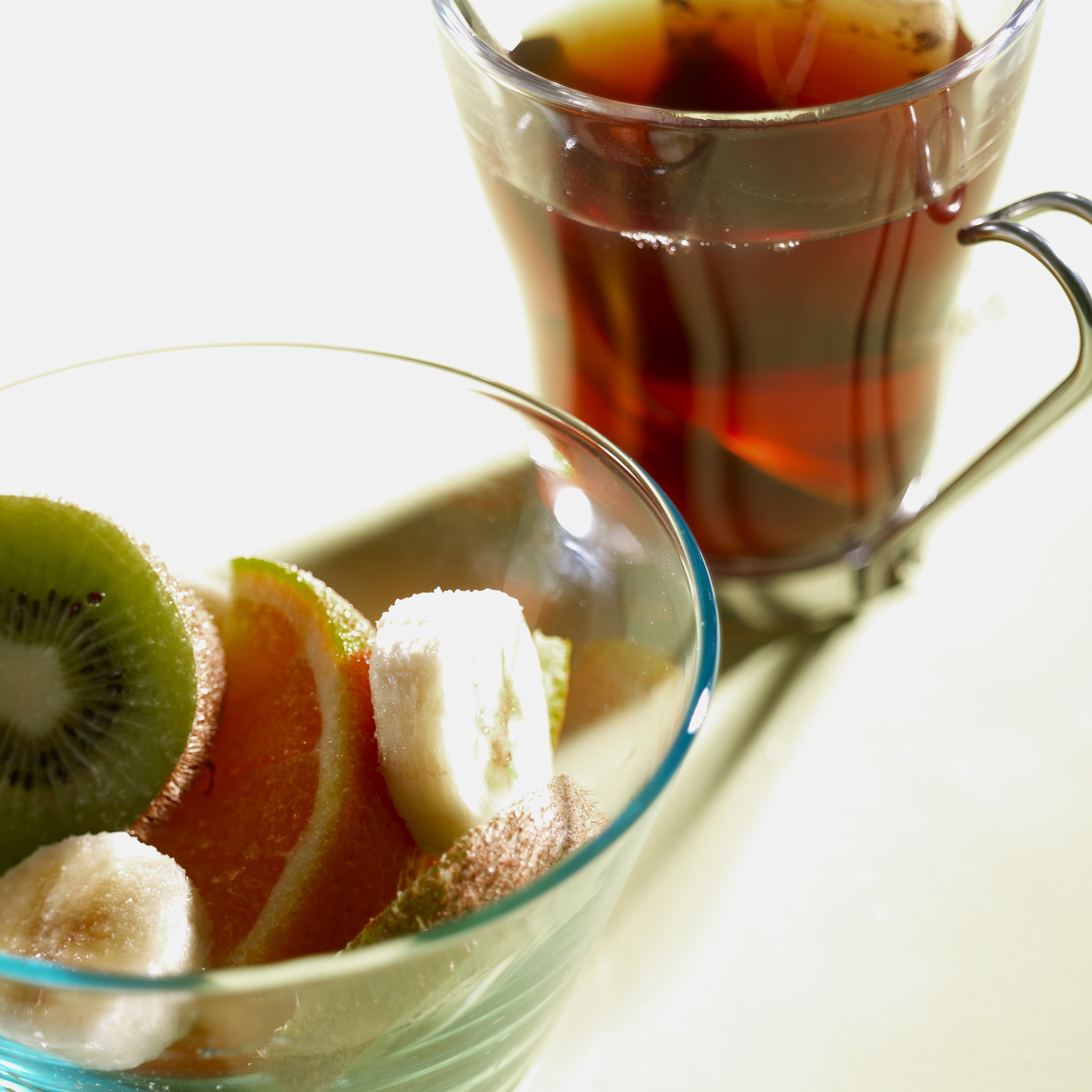 sliced kiwi, orange and bananas in clear drinking glass