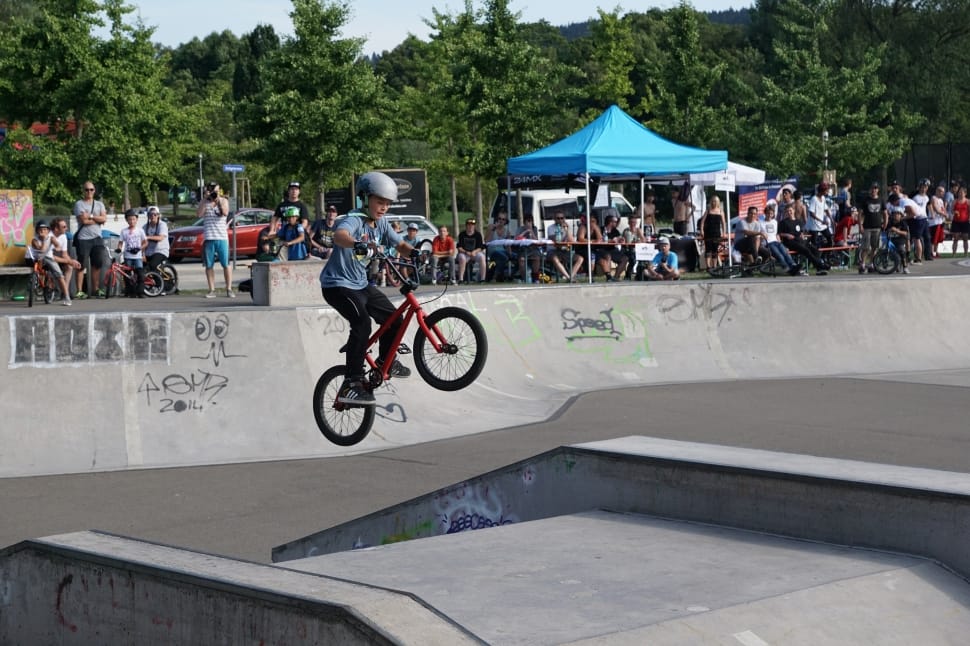 man in blue shirt riding BMX bicycle during daytime preview