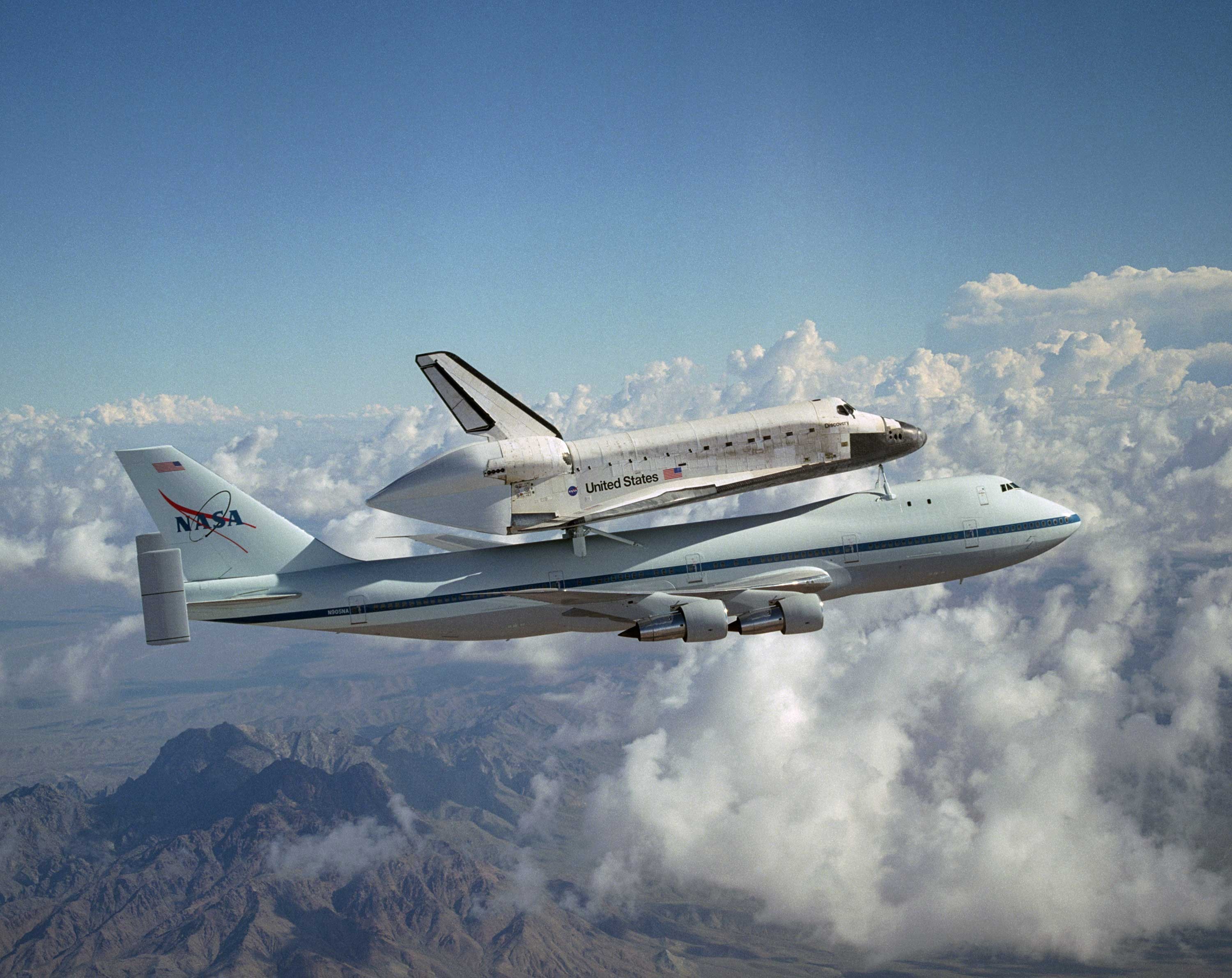 white nasa airliner and white and black space shuttle