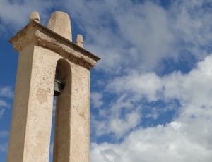 white concrete bell tower near the sky during daytime thumbnail