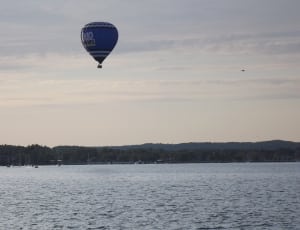 blue hot air balloon on body of water thumbnail