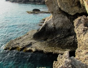 blue sea and gray rock formation thumbnail