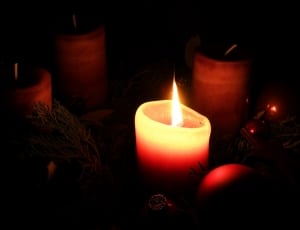 pillar candle lit in darkness thumbnail