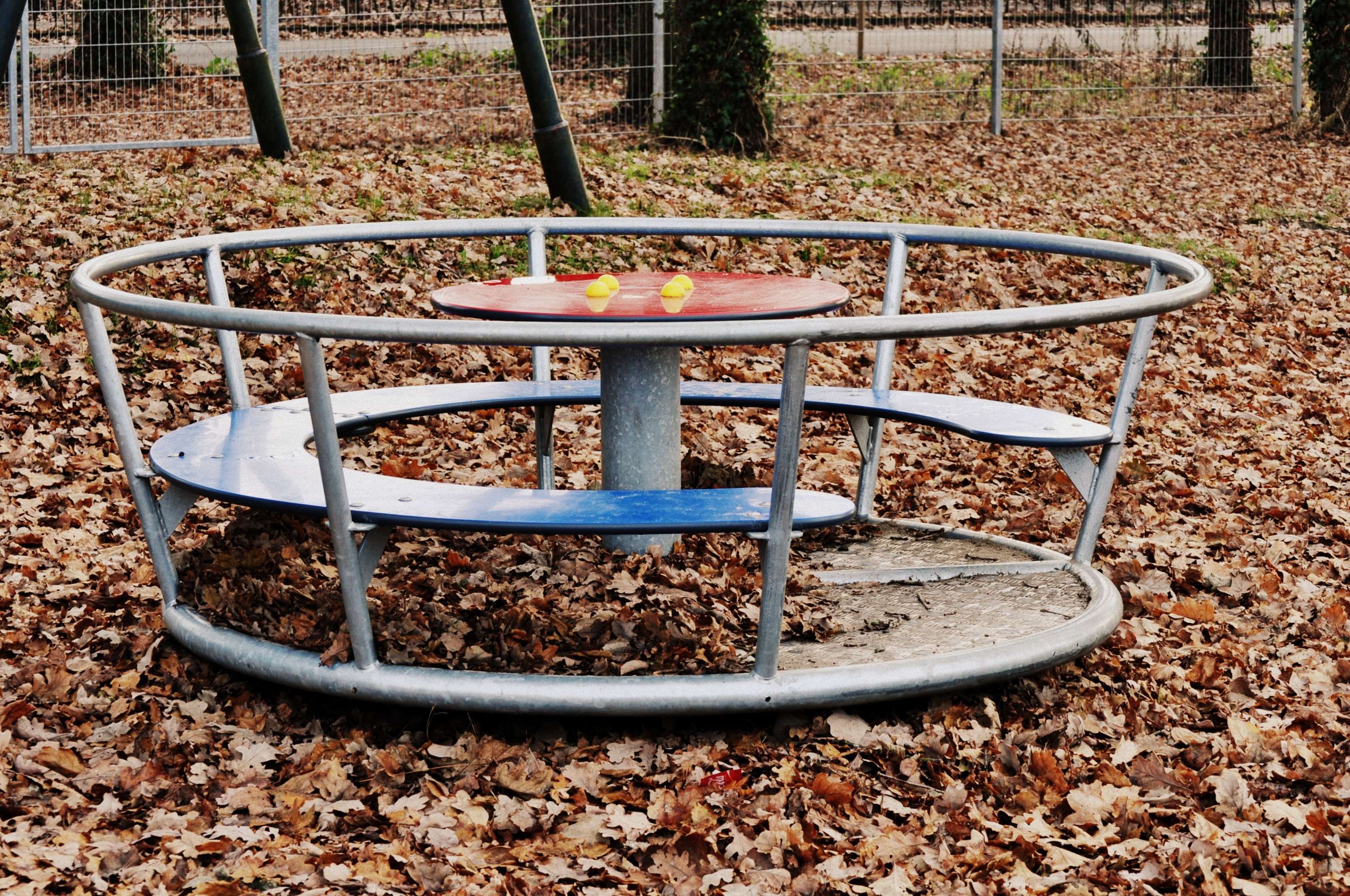 gray metal round table with fence on park