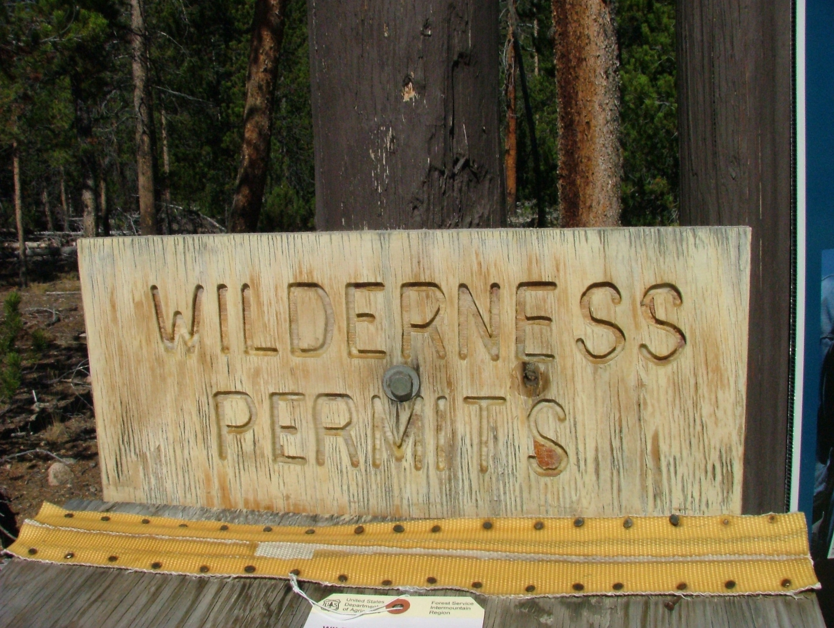 brown wooden wilderness permits signage