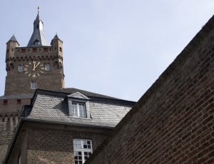 grey brick tower with clock during daytime thumbnail