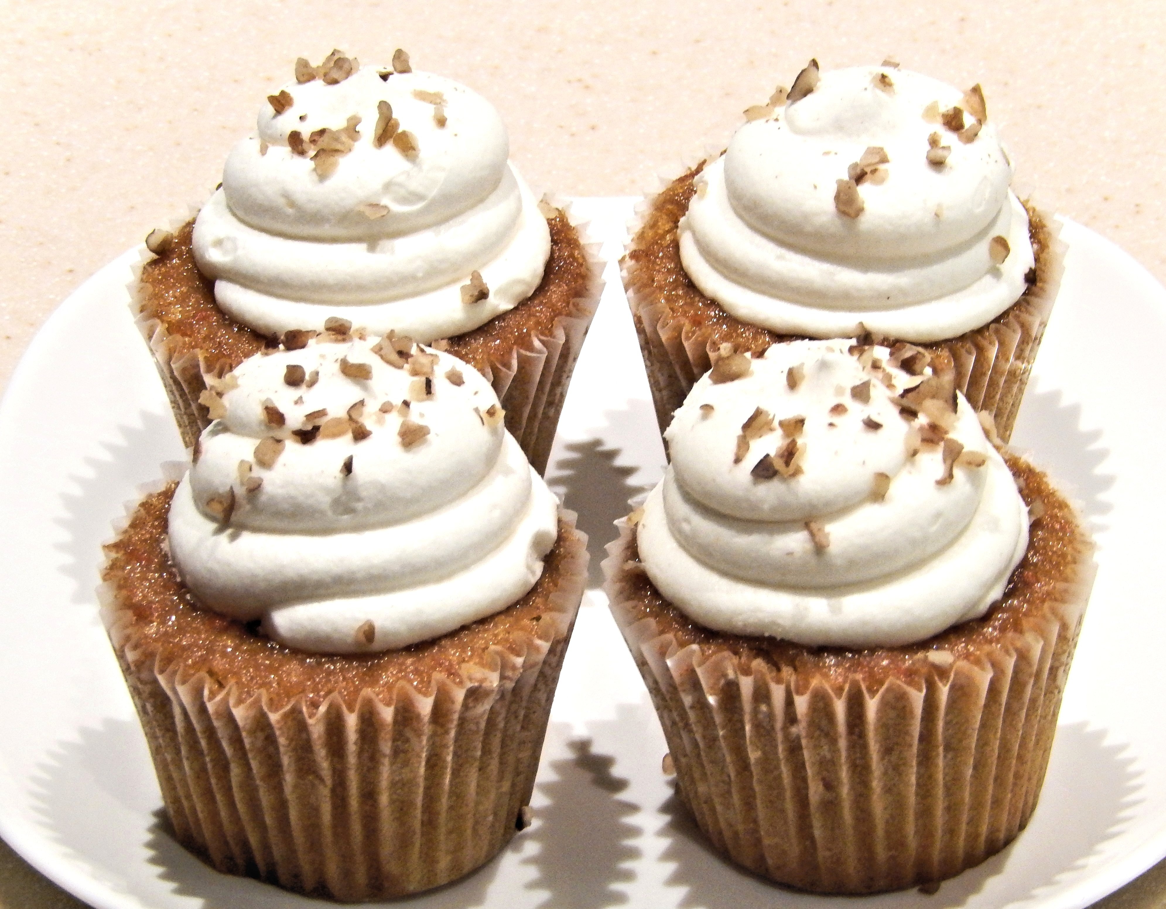 4 brown cupcakes with with creams