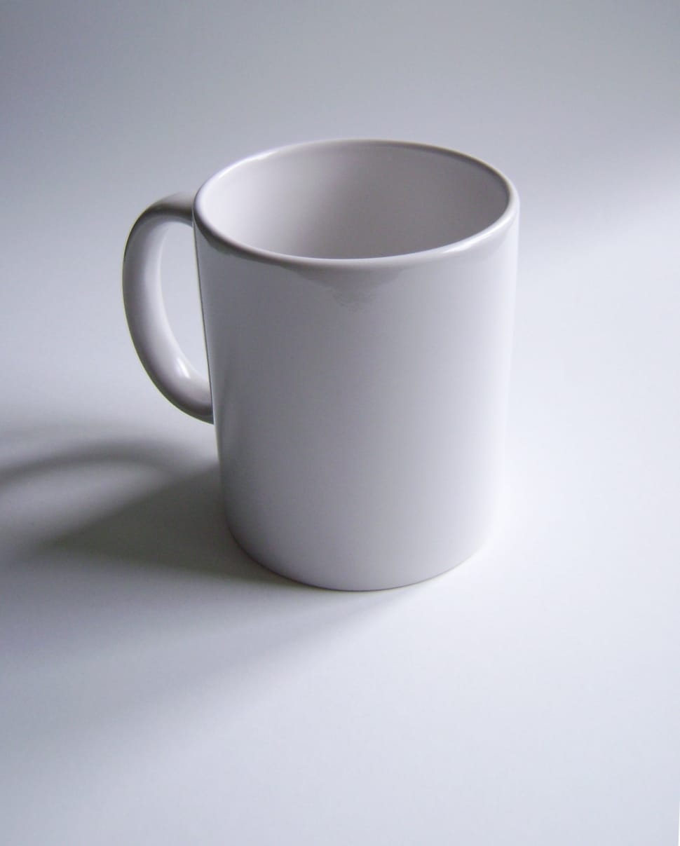 close up photography of a white ceramic mug on top of a white surface preview