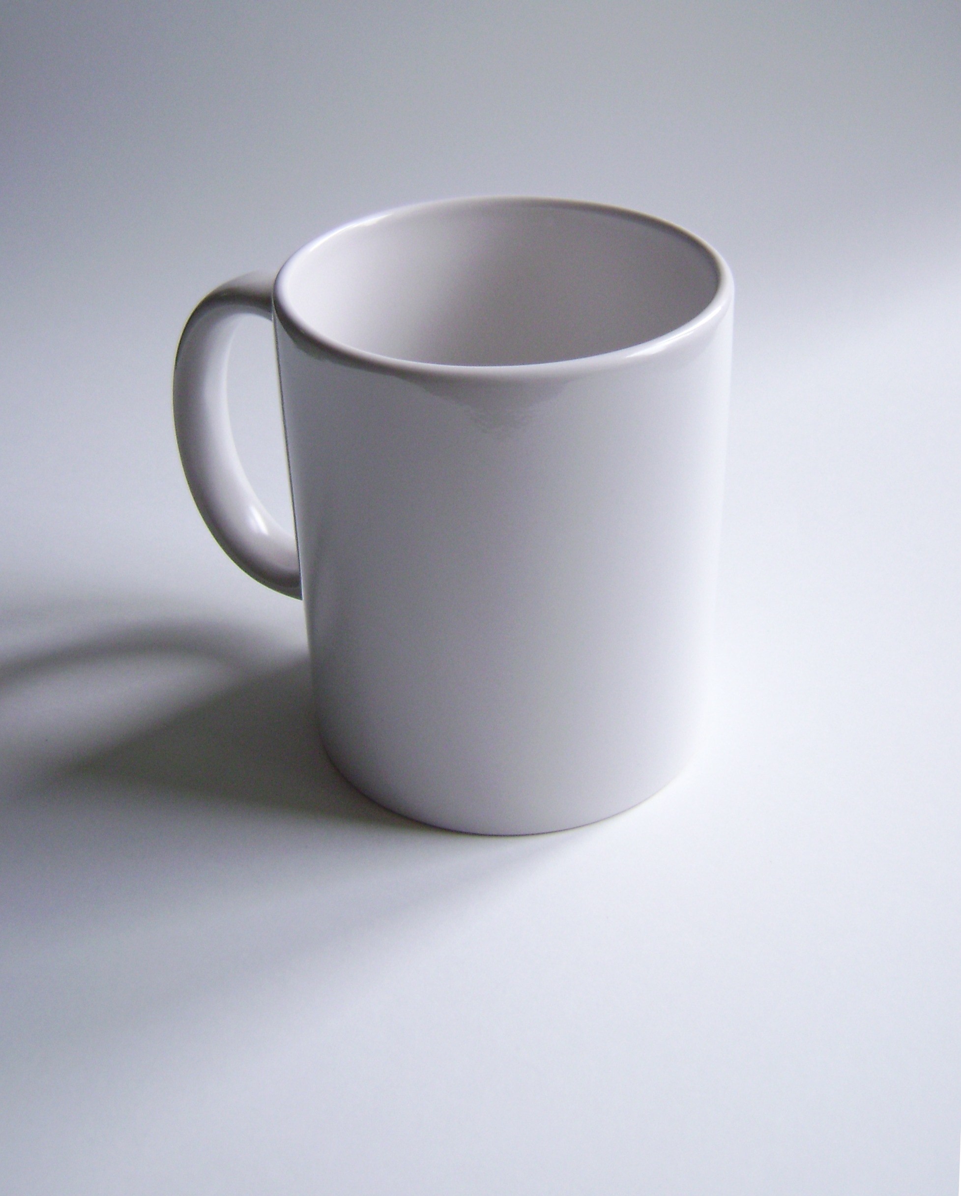 close up photography of a white ceramic mug on top of a white surface