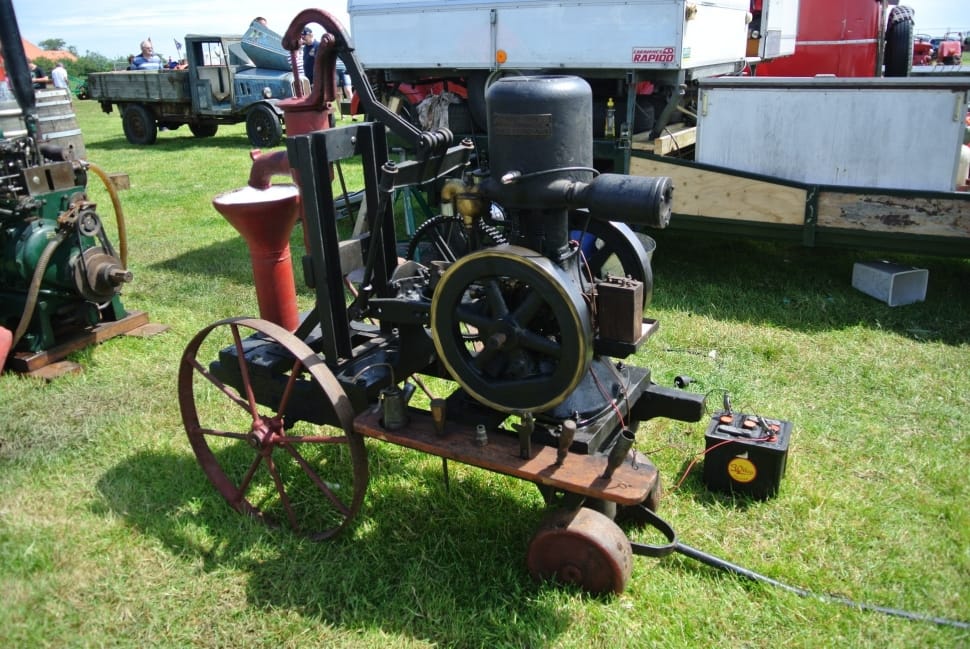 black and red metal machine with battery on lawn yard during daytime preview