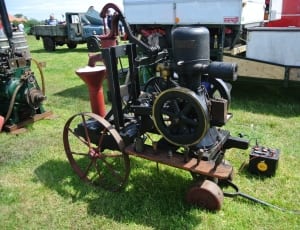 black and red metal machine with battery on lawn yard during daytime thumbnail