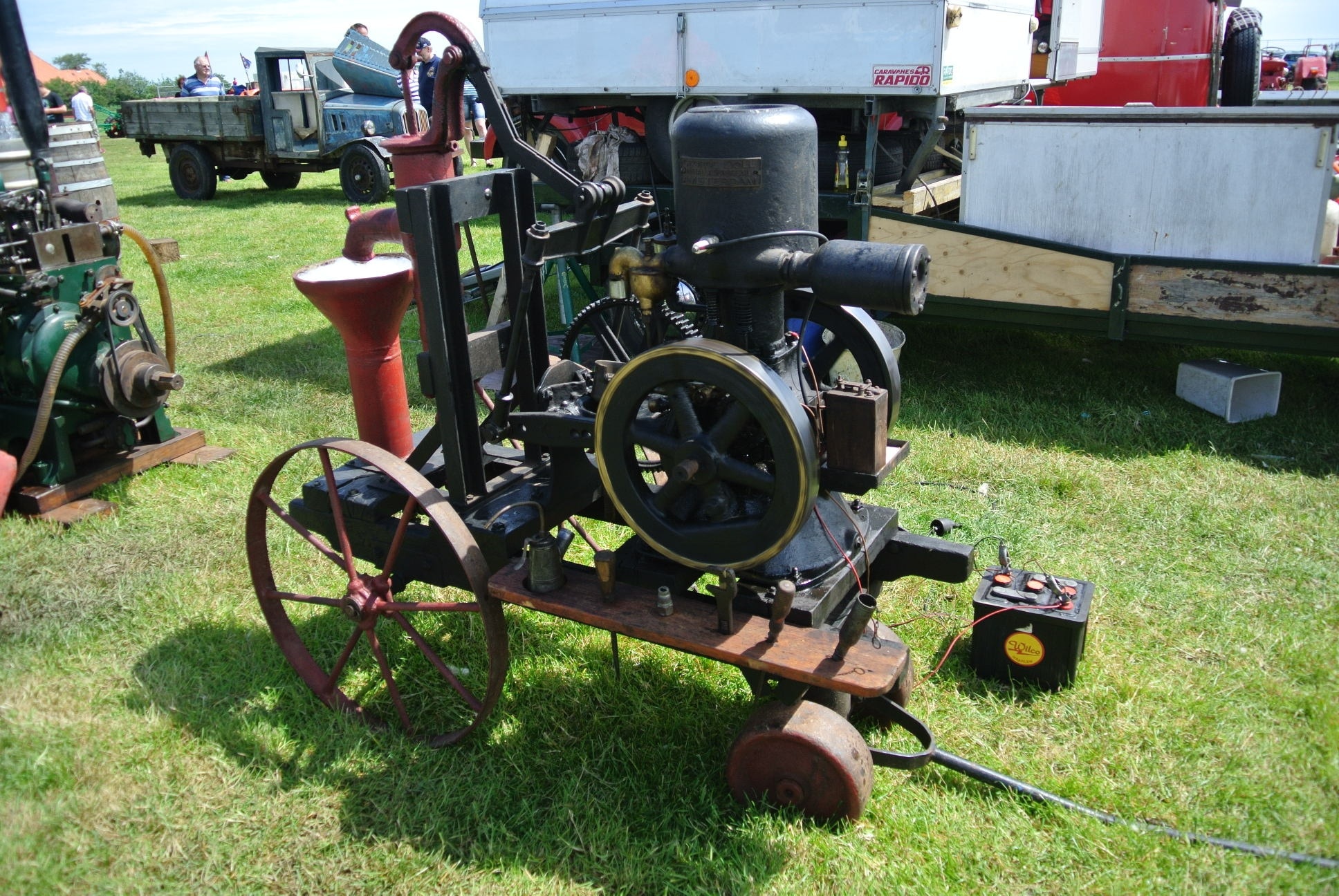 black and red metal machine with battery on lawn yard during daytime