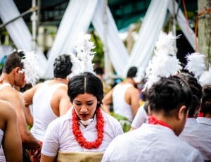 selective focus photo of woman in white collared tops surrounded by people during daytime thumbnail