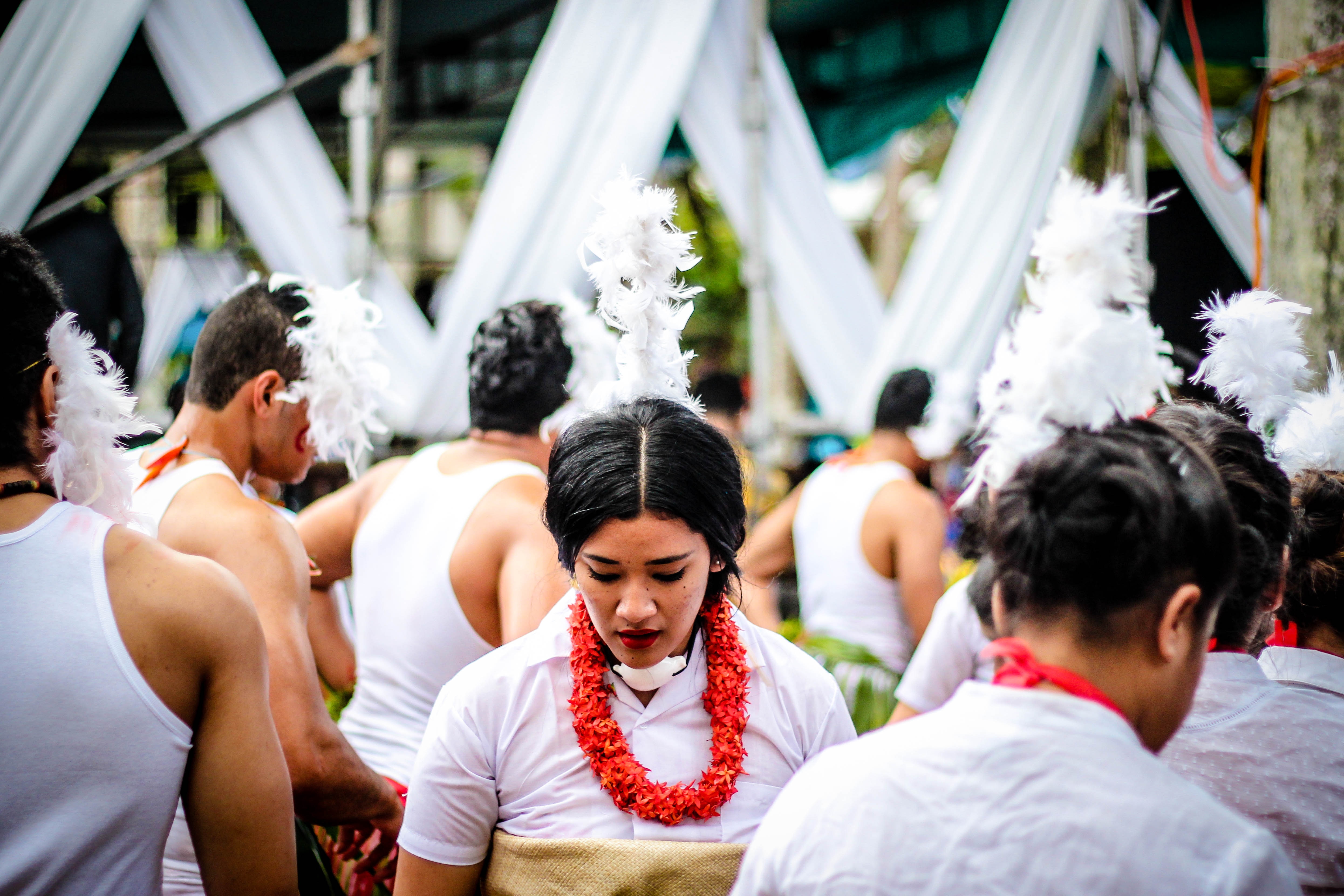 selective focus photo of woman in white collared tops surrounded by people during daytime