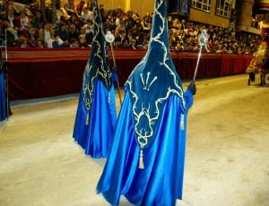 three person wearing blue costume in parade thumbnail