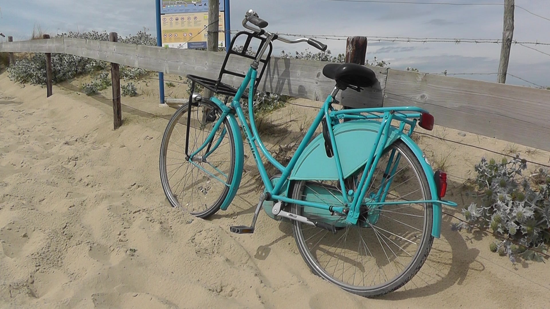 teal beach cruiser bicycle on sand