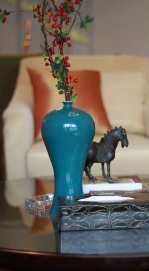 black horse figurine on book near blue flower vase on table thumbnail