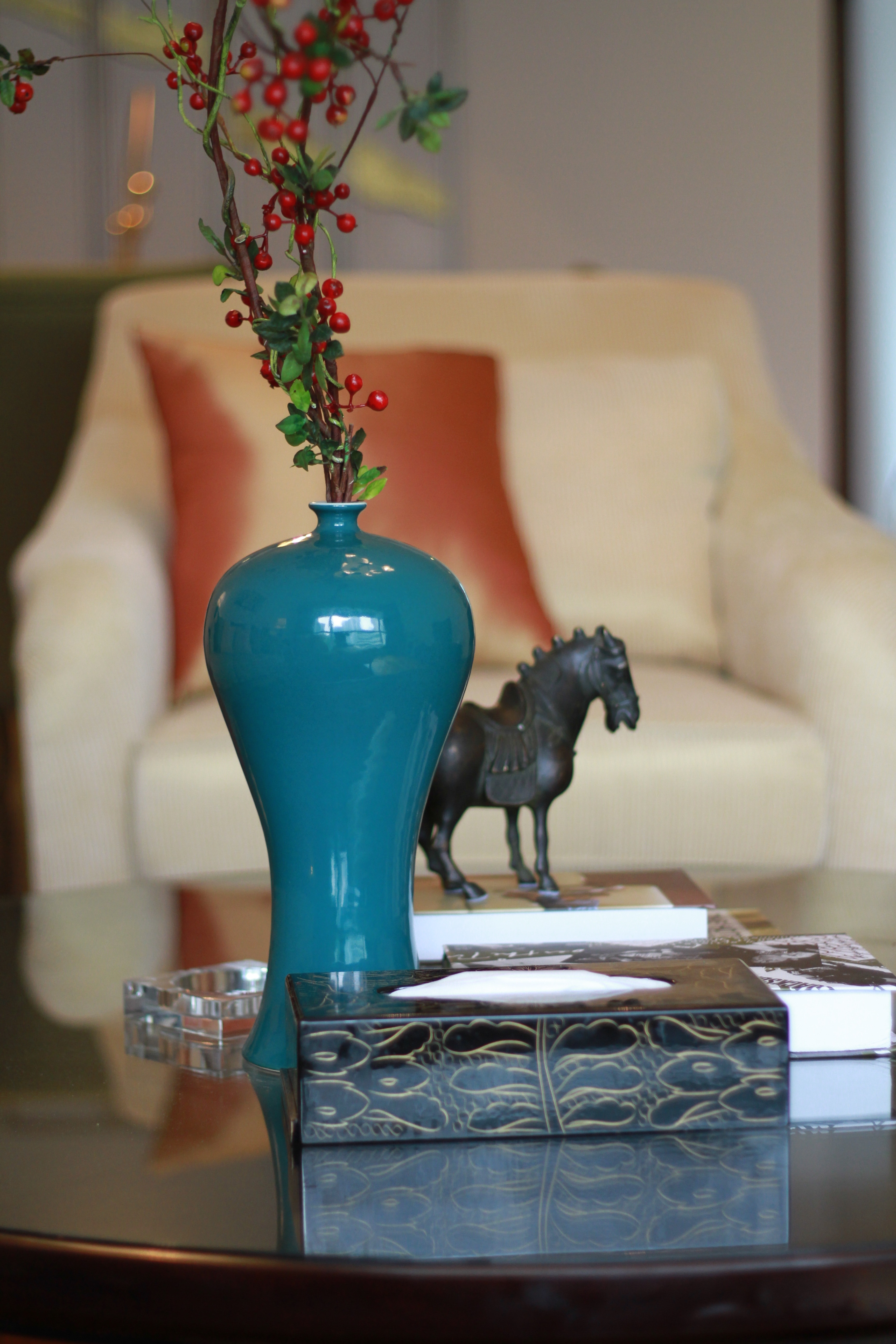 black horse figurine on book near blue flower vase on table