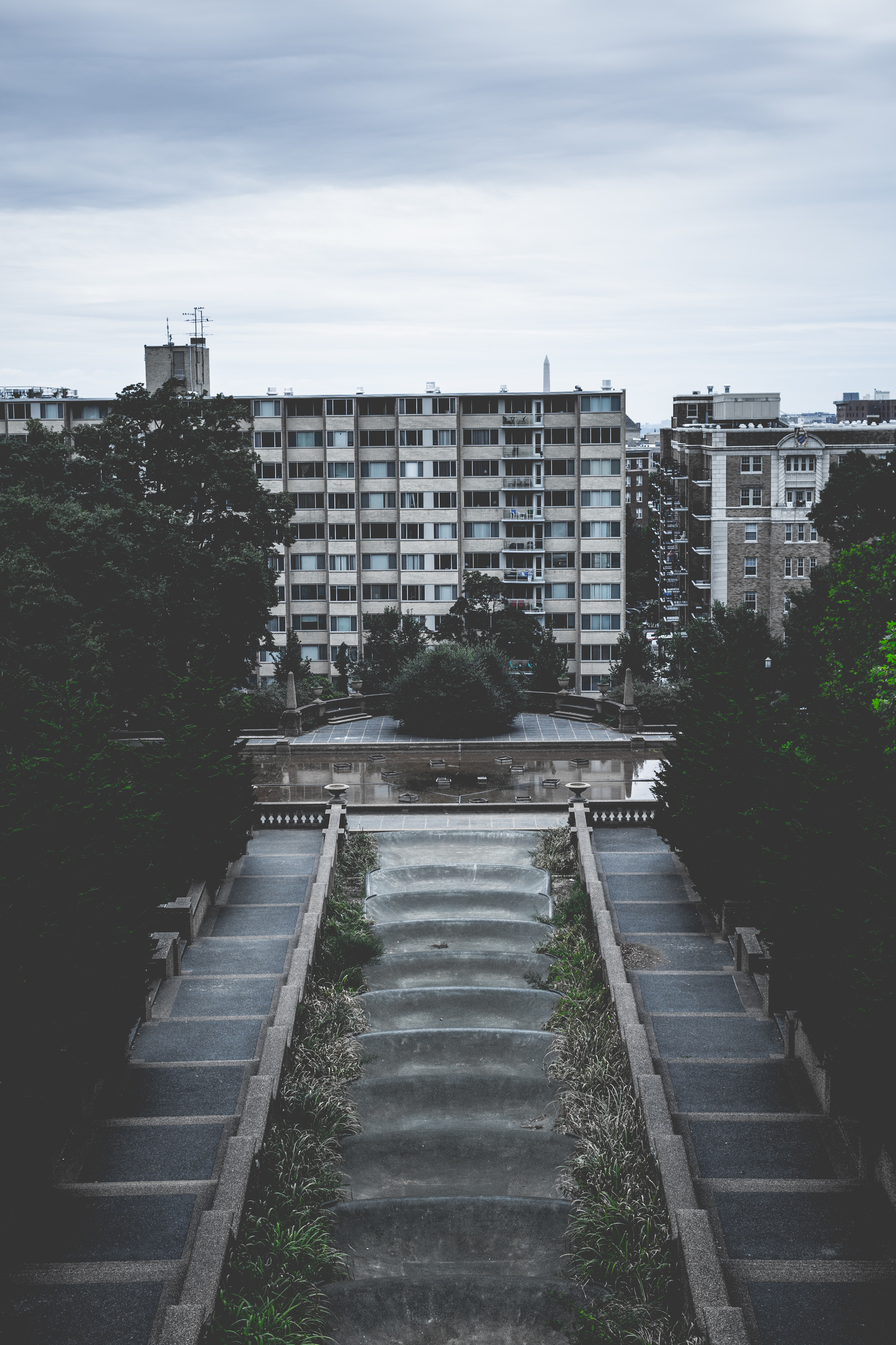 grey concrete stairs near fountain and high rise building photo