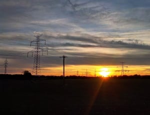 black transmission towers during golden time thumbnail