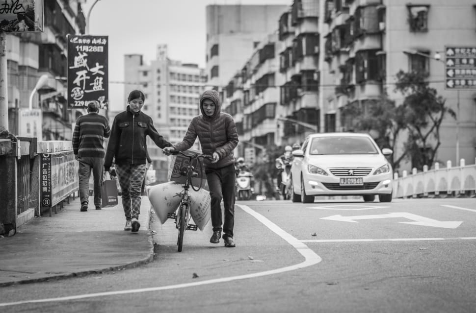 grayscale photo of man and woman pushing bicycle preview