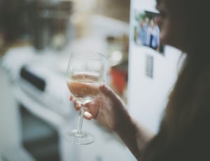 woman holding clear wine glass with liquid thumbnail