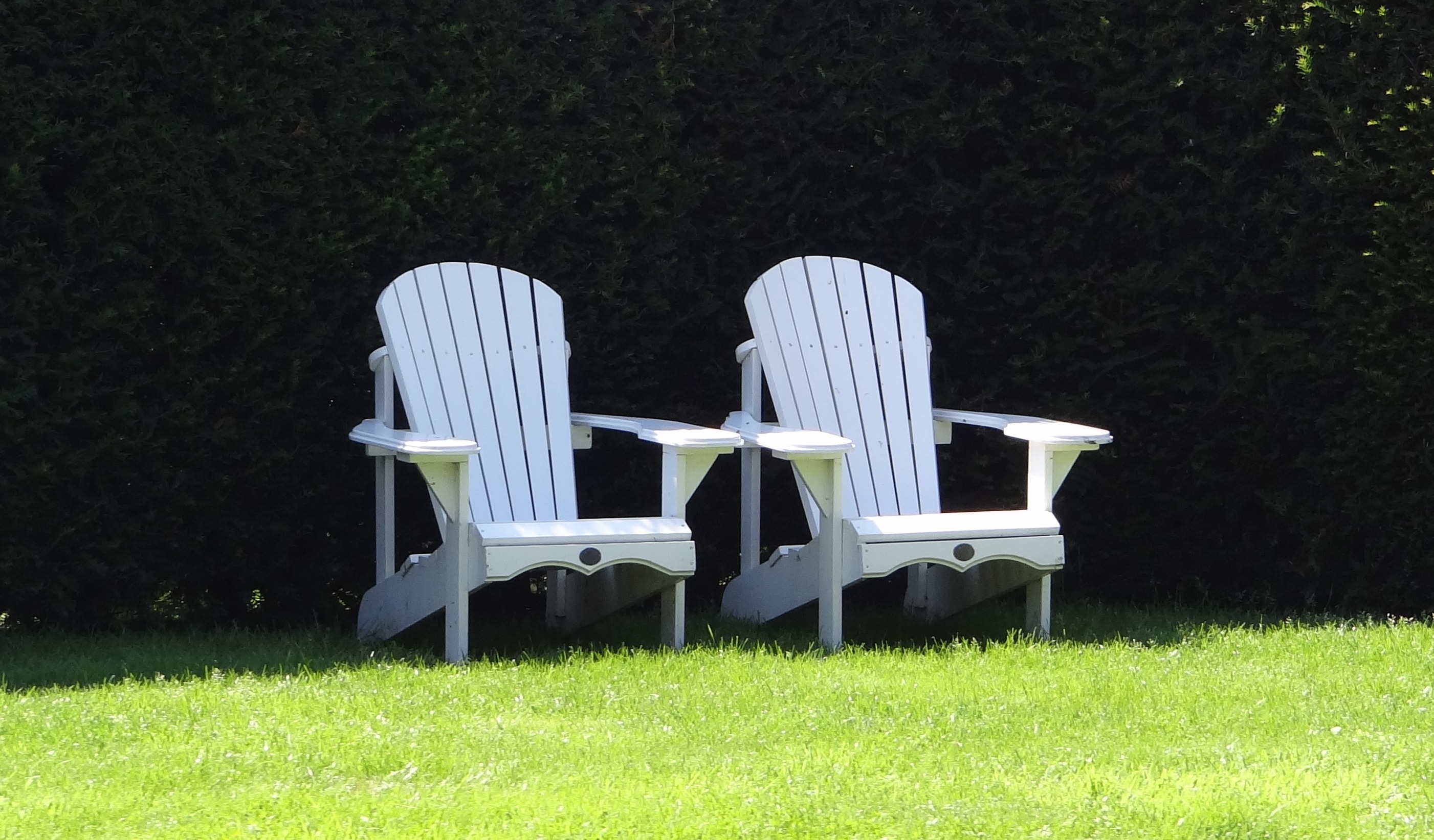 2 white wooden lounge chairs
