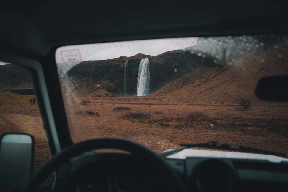 black steering wheel in front of waterfalls preview