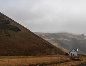 black house with white shed near mountain thumbnail