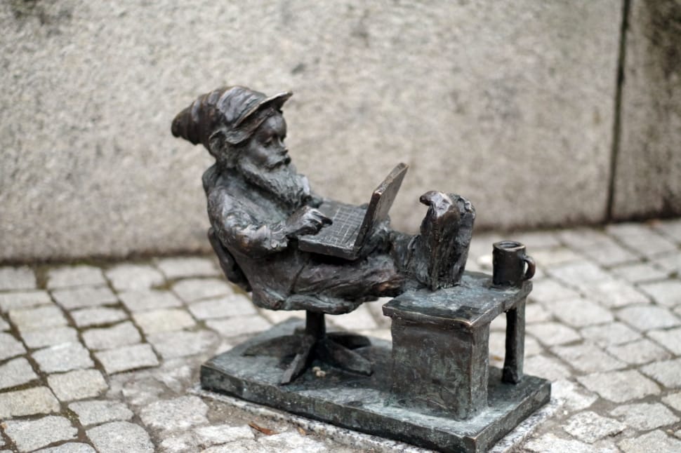 man sitting using laptop computer figurine preview