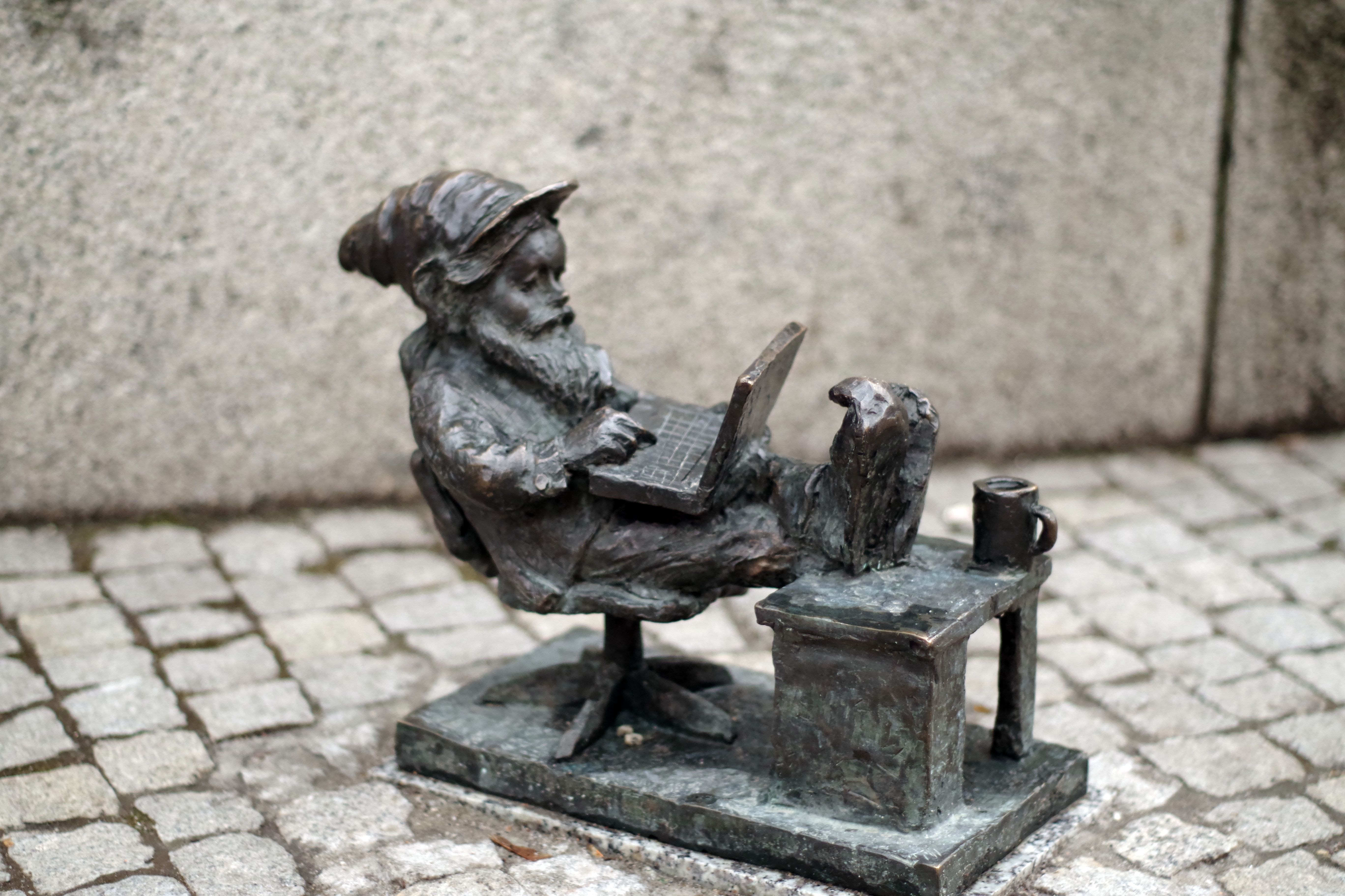 man sitting using laptop computer figurine