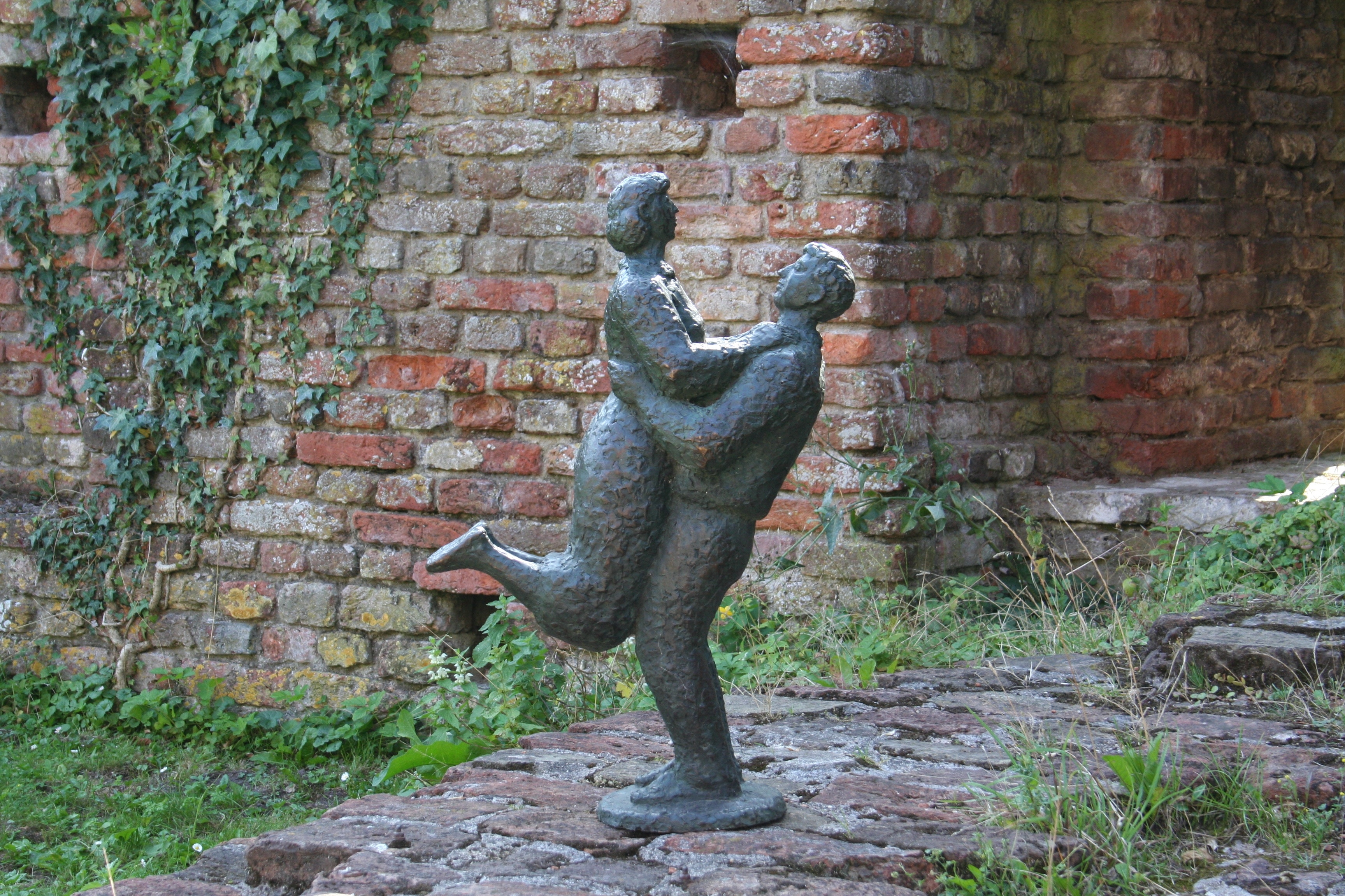 man lifting woman statuette