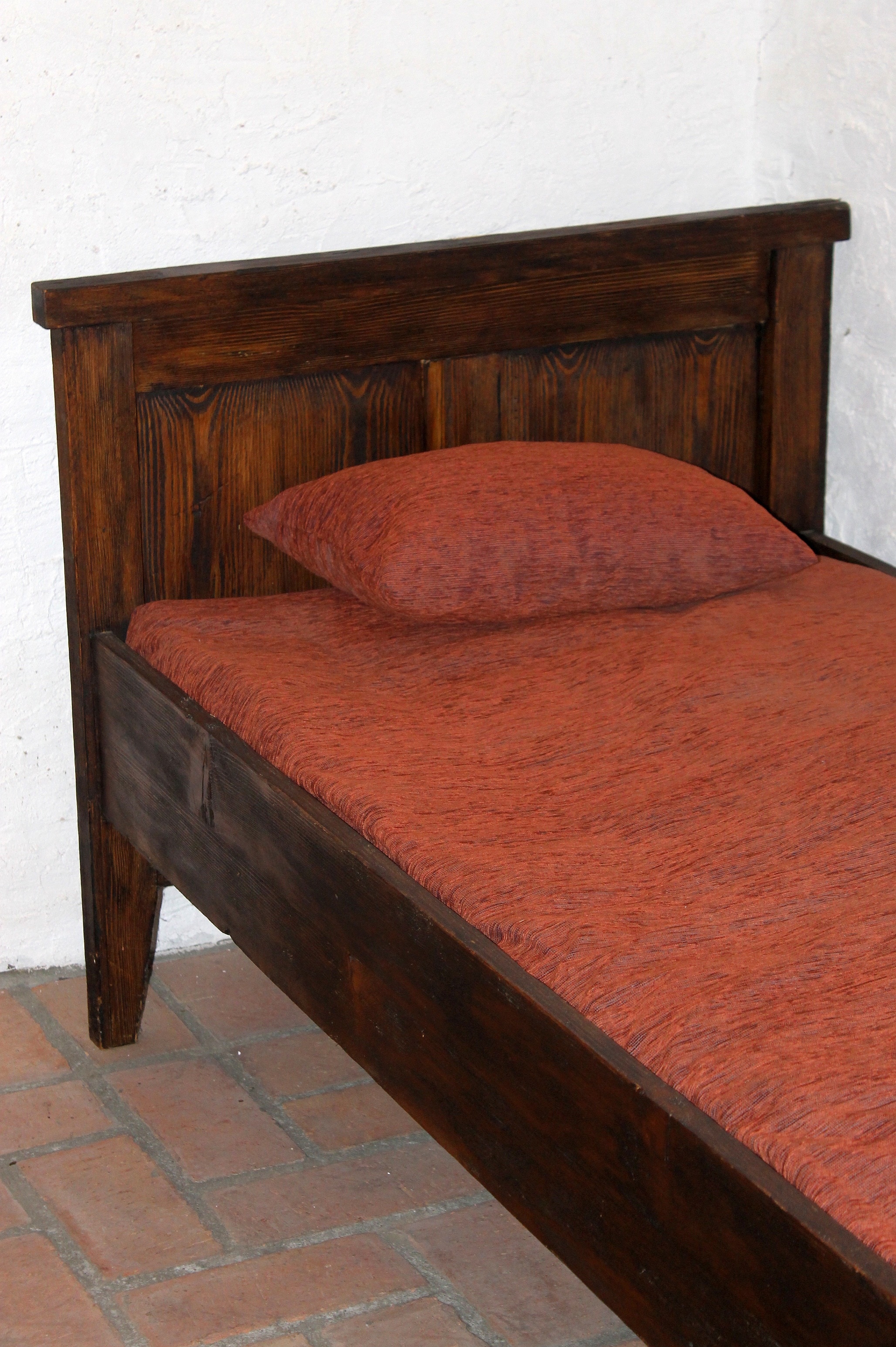 brown wooden bed frame with red fabric padded bed mattrsss