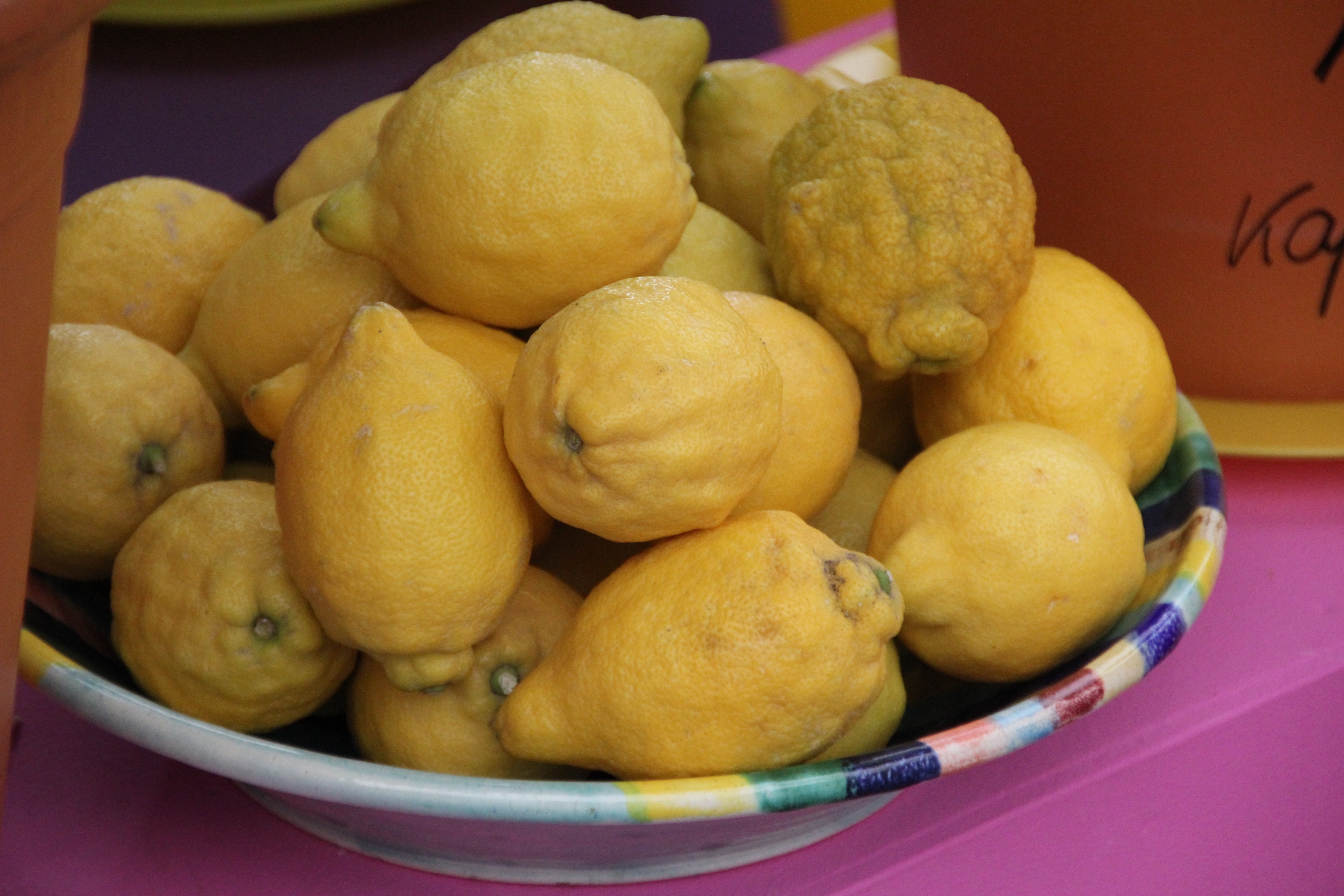 yellow lemons on round multi color bowl