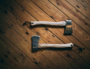 pair of hatchets on wooden surface thumbnail