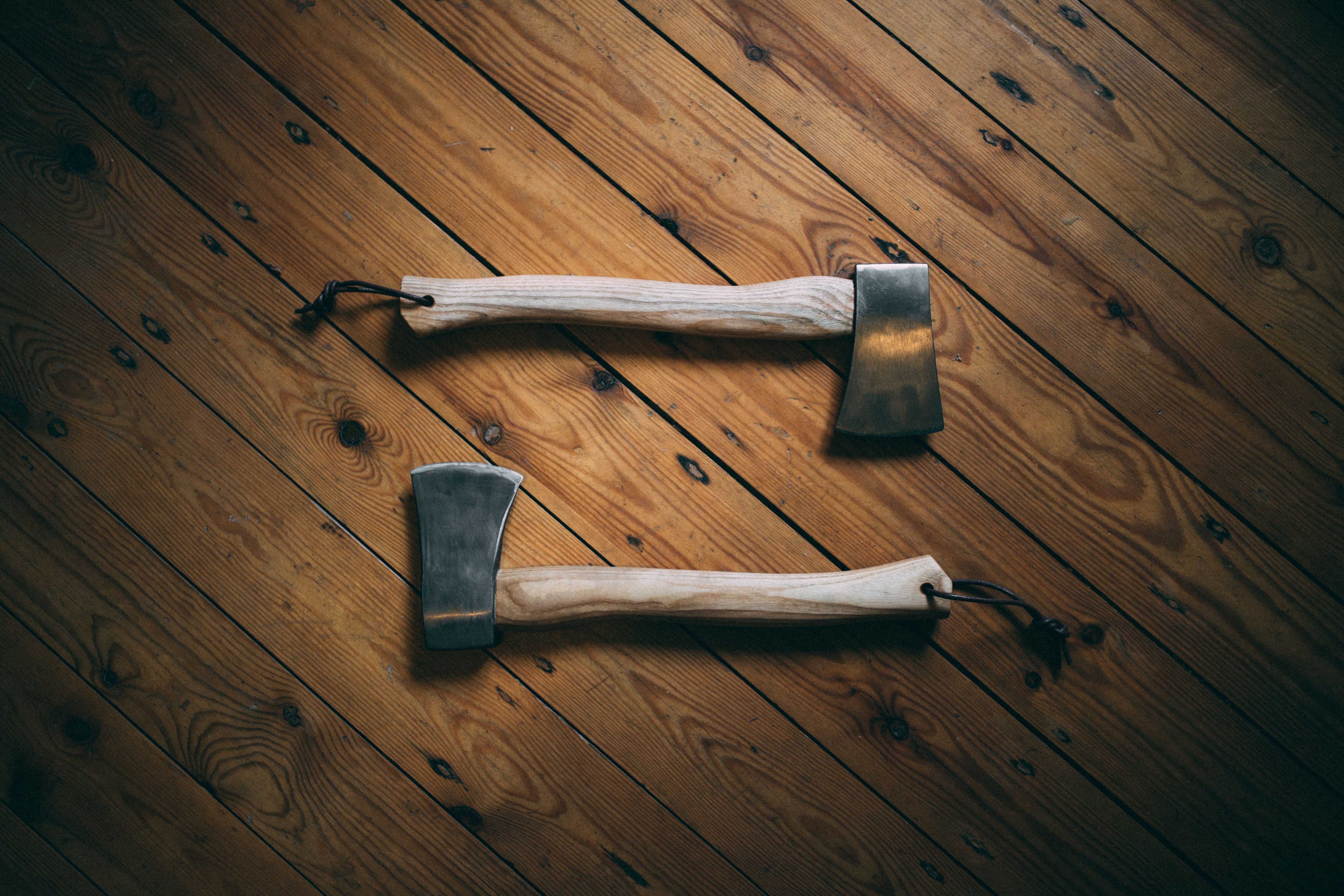 pair of hatchets on wooden surface