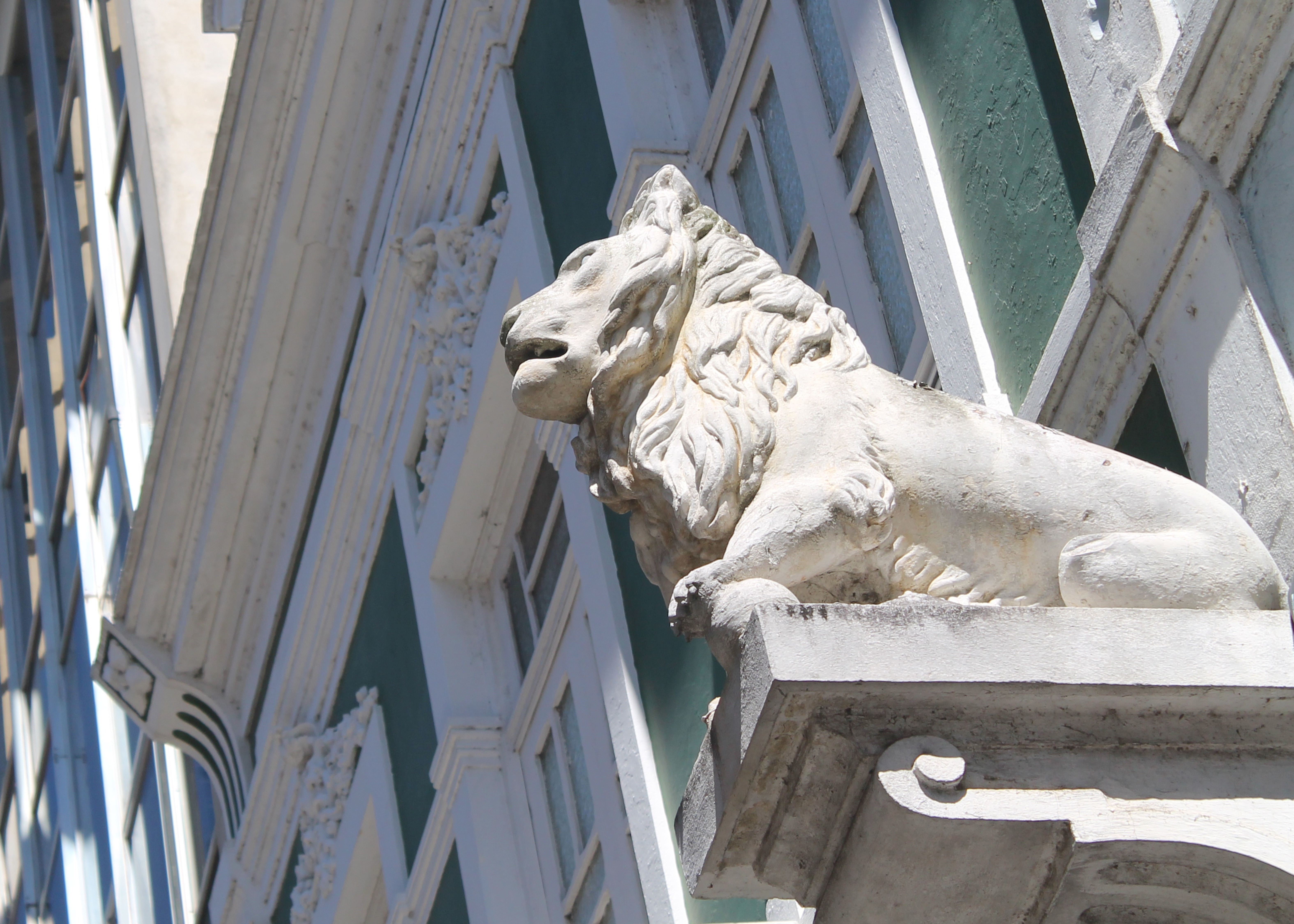 white concrete lion statuette