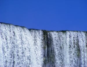 waterfalls under blue sky thumbnail