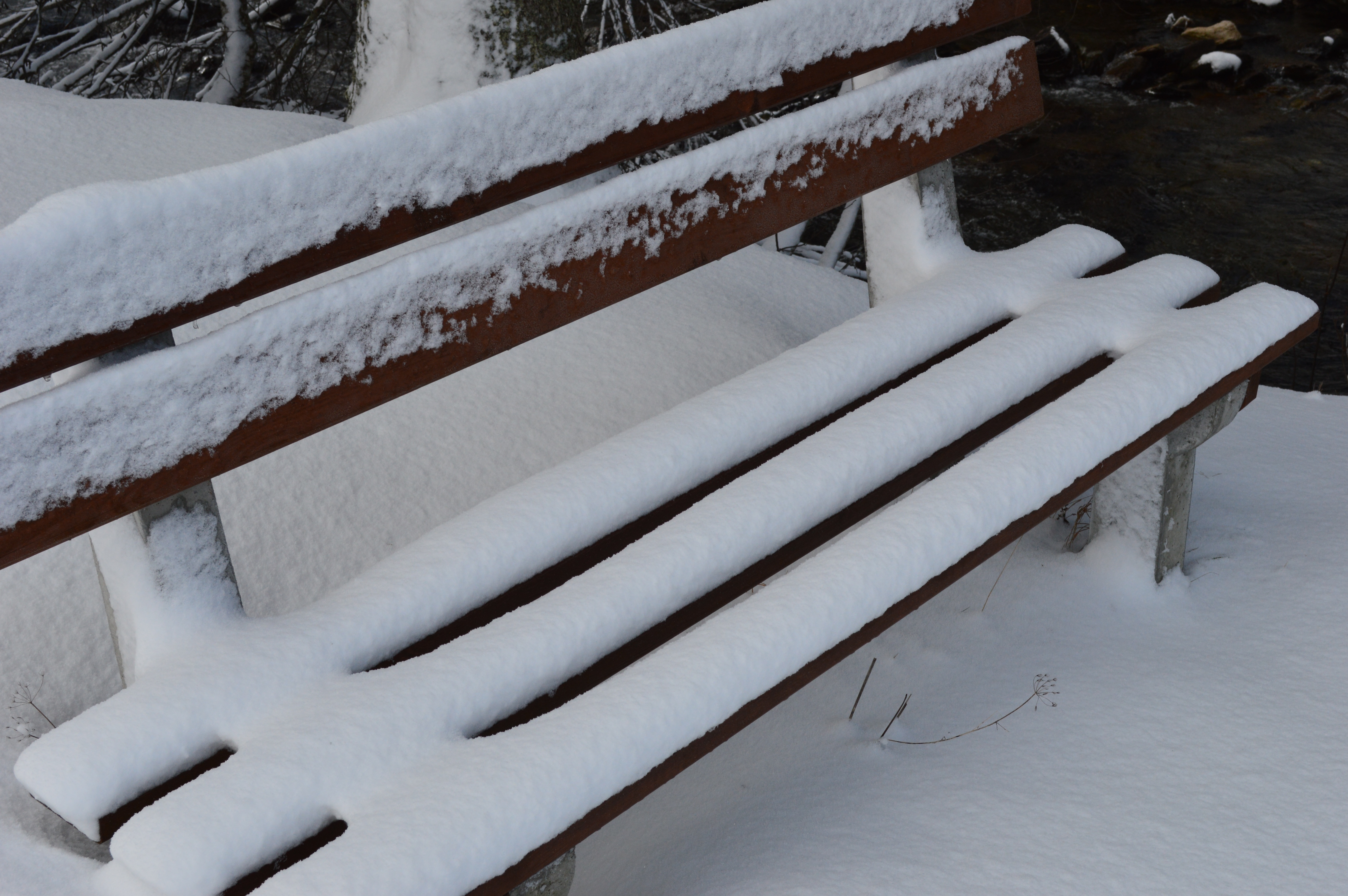 snow covered wooden bench